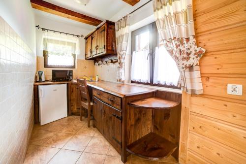 a kitchen with wooden cabinets and a counter top at Solny - Resort w Bieszczadach in Cisna