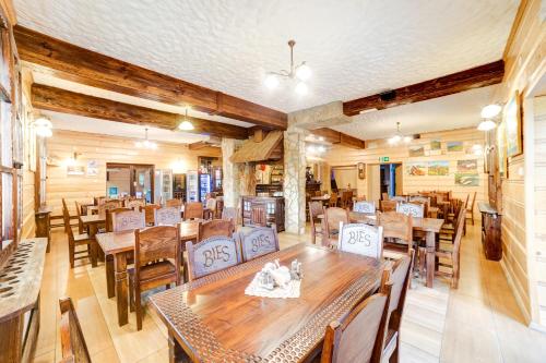 a dining room with wooden tables and chairs at Solny - Resort w Bieszczadach in Cisna