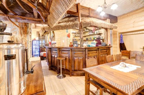 a restaurant with a bar and a table and chairs at Solny - Resort w Bieszczadach in Cisna