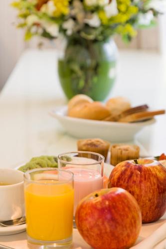 a tray with apples and two glasses of orange juice at Intercity Porto Alegre Praia de Belas in Porto Alegre