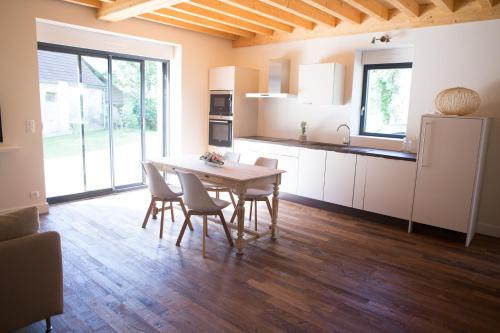 une cuisine et une salle à manger avec une table et des chaises dans l'établissement La Grange aux Ecureuils, à Levernois