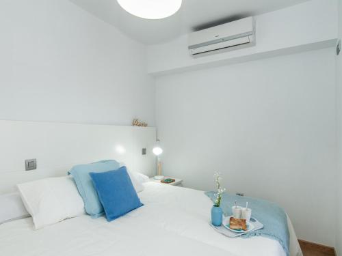 サンアグスティンにあるSeaviews & Terrace Apartment San Agustin Las Floresの白いベッドルーム(青い枕の白いベッド付)