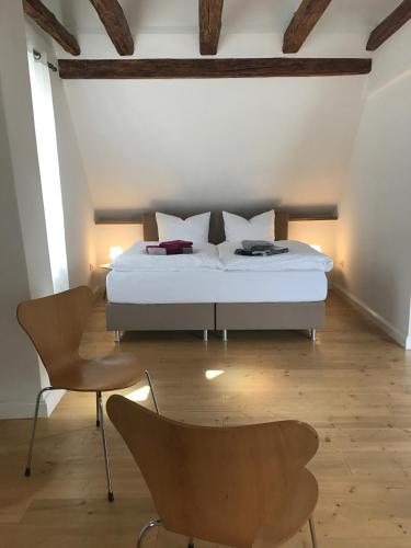 a bedroom with a bed and two chairs in it at Herrenhaus - Weingut Freiherr v. Landenberg in Ediger-Eller