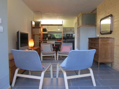 sala de estar con 2 sillas azules y cocina en Vignalunga, en Mondovì