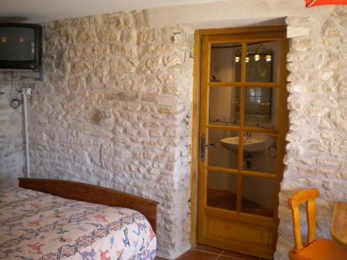 Chambre d'hôte Au col de Cygne في Blanzac-lès-Matha: غرفة نوم بسرير ومغسلة وباب