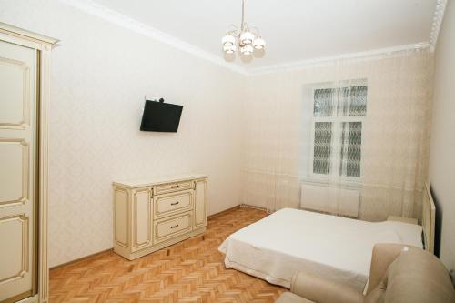 sypialnia z łóżkiem, komodą i telewizorem w obiekcie Apartment on Stefanyka 11 w Lwowie