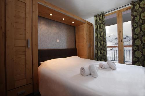a bedroom with a bed with two towels on it at Chalet des Neiges : La Cime Des Arcs in Arc 2000
