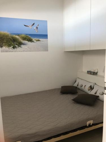 een slaapkamer met een bed waar vogels over het strand vliegen bij Apartment S7 in Oostende