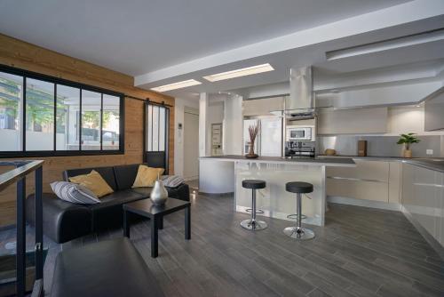 - un salon et une cuisine avec un canapé et un comptoir dans l'établissement Capucine Duplex, à La Ciotat