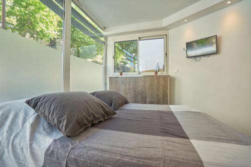 une chambre avec un lit avec une grande fenêtre dans l'établissement Capucine Duplex, à La Ciotat