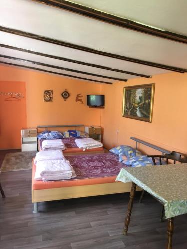 two beds in a room with a table at Ubytovanie v hosťovskom dome Flower in Veľký Meder
