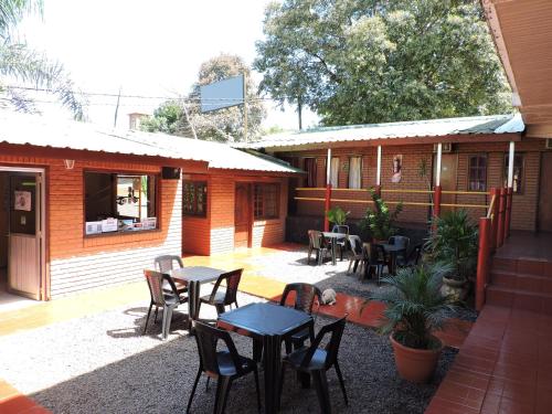 a patio with tables and chairs in front of a building at Hostel Park Iguazu in Puerto Iguazú
