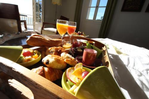 een houten dienblad met eten en twee glazen wijn bij Villa La Tosca in Lanton