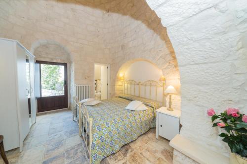 セルヴァ・ディ・ファザーノにあるTrulli Curriの石壁のベッドルーム1室