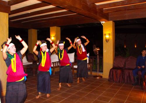 a group of people dancing with their hands in the air at Temple Tree Resort & Spa, Pokhara in Pokhara