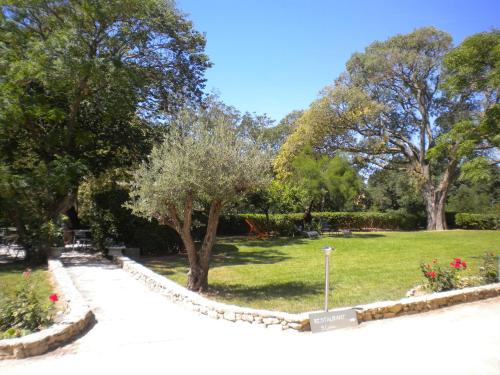 a park with a tree and a walkway at Logis Hôtel Château De Palaja in Carcassonne