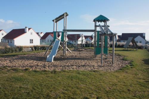 einen Spielplatz mit Rutsche in einem Park in der Unterkunft Wenduine zeehuisje 16 in Wenduine