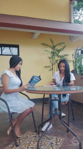 two women sitting at a table with at Hostal La Molienda in Puyo