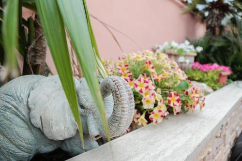 a statue of an elephant next to some flowers at Villa Erasi in Fiumicino