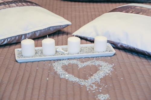 a tray with candles and a heart on a bed at Villa Erasi in Fiumicino