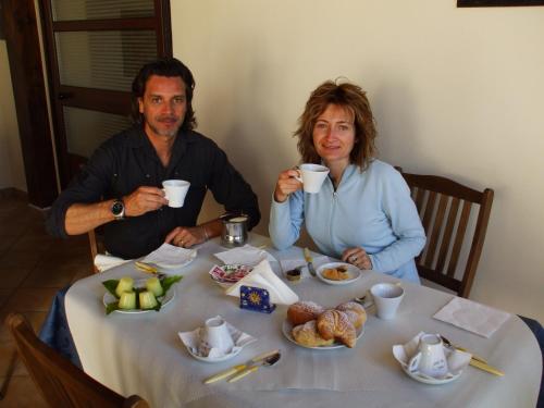 een man en vrouw aan een tafel met kopjes koffie bij Cabrera House in Pozzallo