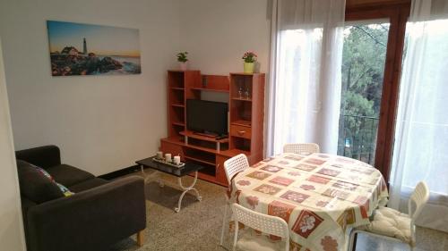 een woonkamer met een tafel en een televisie bij Apartamentos Juan Jose in Lloret de Mar