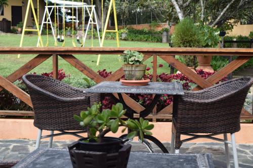 a table and two chairs with plants on a patio at Hotel Rancho Constanza & Cabañas de la Montaña in Constanza