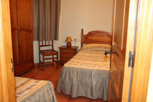 AreuにあるApartaments l'Hortalのベッドルーム(木製ベッド1台、椅子付)