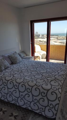 a bedroom with a bed and a balcony with a view at Porto Sea Apartments in Matosinhos