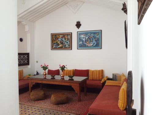 a living room with a table and a couch at Riad Arous Chamel in Tangier