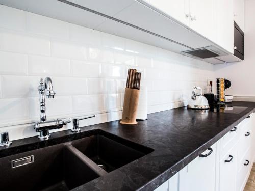 fregadero con encimera negra en Ambre Apartments, en Łeba
