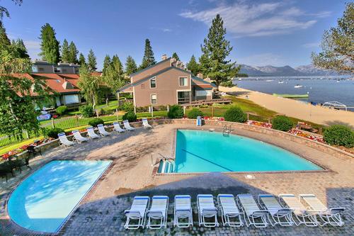 サウス・レイクタホにあるSouth Lake Tahoe Resort - Steps to Beach & Close to Heavenlyの大きなスイミングプール(椅子付)と家