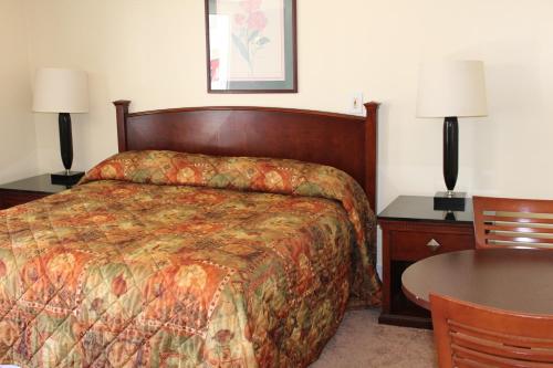a hotel room with a bed and a table and lamps at Royale Coach Motor Lodge in Hampton