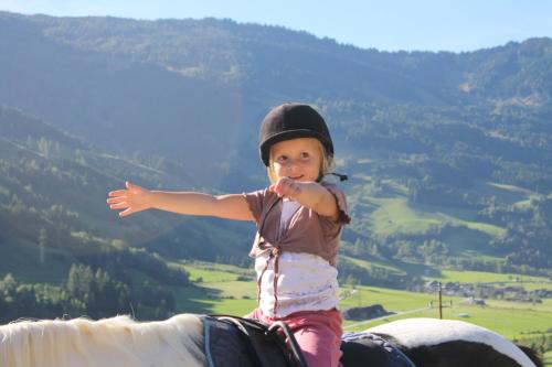 a little girl riding on a horse at Tobhartbauer in Dorfgastein