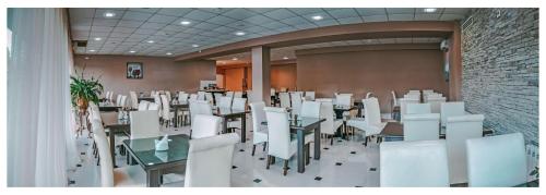a room with white tables and white chairs at Tskaltubo Hotel Prometheus in Tskaltubo
