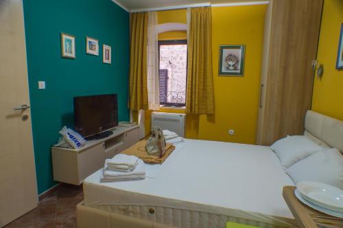 1 dormitorio con 1 cama y TV en Apartments Casa del Sol Jovana, en Kotor