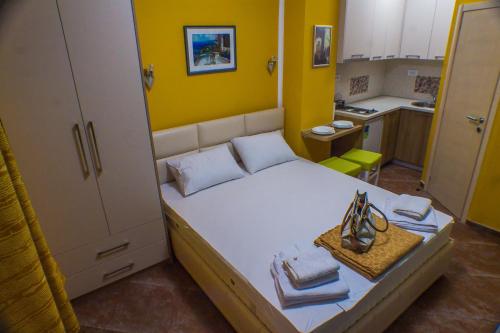 ein kleines Schlafzimmer mit einem Bett mit gelber Wand in der Unterkunft Apartments Casa del Sol Jovana in Kotor