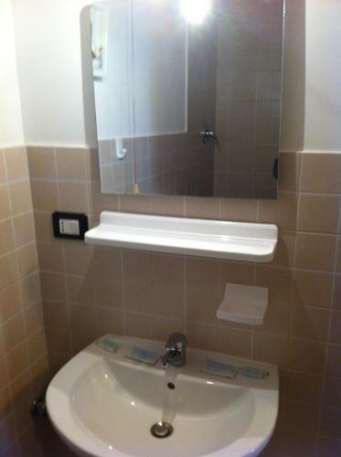 y baño con lavabo blanco y espejo. en Albergo Panson en Génova