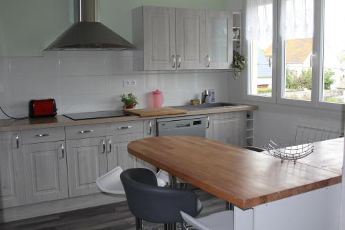 une cuisine avec des armoires blanches et une table en bois dans l'établissement Appartement lumineux et Agréable 6 Personnes, à Saint-Malo