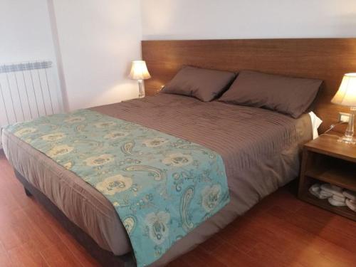 a bedroom with a large bed with a wooden headboard at B&B Il Prugnolo in Castel di Sangro