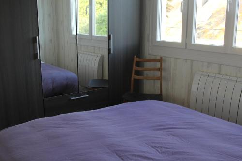 1 dormitorio con cama, espejo y silla en Appartement lumineux et Agréable 6 Personnes, en Saint-Malo