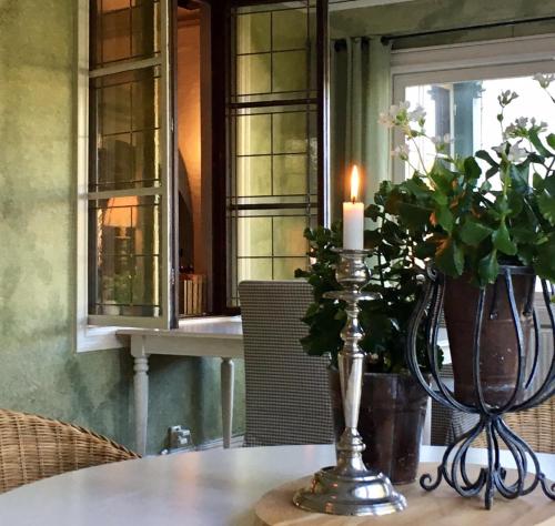 a candle sitting on top of a table with a vase at Kisa Wärdshus & Hotell in Kisa