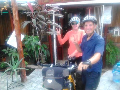 a man and a woman standing next to a scooter at Hostel Julieta in Rivas