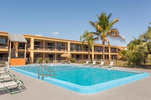 a swimming pool in front of a building with a resort at Travelodge by Wyndham Fort Myers North in North Fort Myers