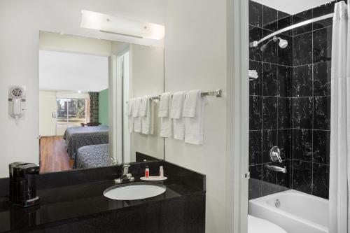 a bathroom with a sink and a mirror at Travelodge by Wyndham Fort Myers North in North Fort Myers