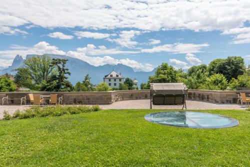a patio with a table and chairs in the grass at Hotel Bemelmans-Post in Collalbo