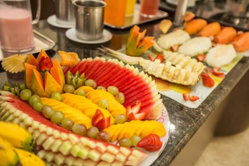 a buffet with many different types of fruit on plates at Pousada Big Bear in Campos do Jordão