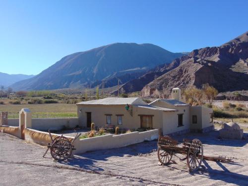 a building in the middle of a desert with mountains at Sendero De Las Cabras in Purmamarca