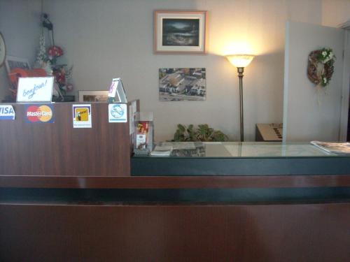 a reception desk in a waiting room with a light at Motel Seigneurie de Vaudreuil in Vaudreuil-Dorion