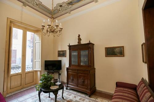 Una sala de estar con un sofá y una lámpara de araña. en Dimora La Commare, en Marsala